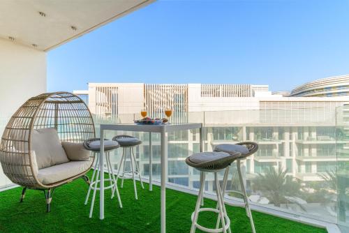 a balcony with a table and chairs and a view of a building at Desert Key - Beachfront Apartments on Saadiyat Island in Abu Dhabi
