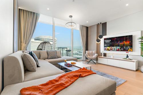 a living room with a couch and a tv at Desert Key - Beachfront Apartments on Saadiyat Island in Abu Dhabi