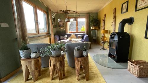 un soggiorno con divano e stufa a legna. di Ferienwohnung Rosen-Holz, Ruhe und Entspannung im Dorf a Niederdorla