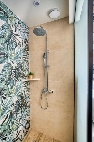 a shower with a shower head in a bathroom at Ephantasy Living - Premium City Apartments in Heraklio