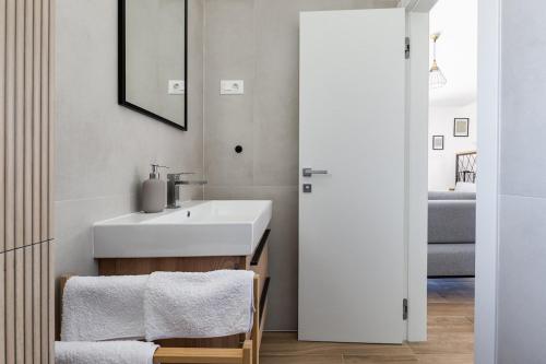 a bathroom with a white sink and a mirror at Villa Franka - holiday home with a private pool in Sveti Filip i Jakov