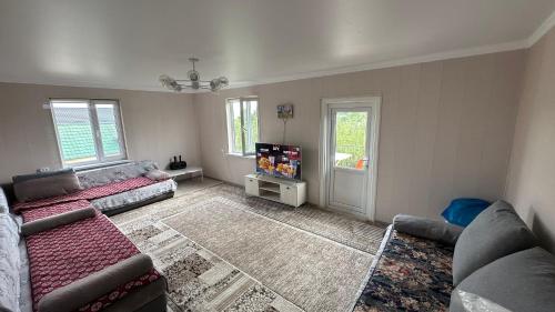 een woonkamer met twee banken en een tv bij Чолпон-Ата! 700 м от берега! in Cholpon-Ata