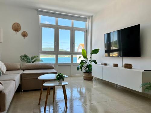a living room with a couch and a flat screen tv at Apartamento SOLPOR in Finisterre