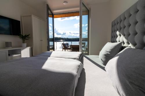 a bedroom with two beds and a view of the ocean at Lilla älg -Ferienhaus am Älgsjön in Arvika
