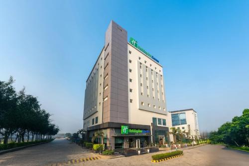 a tall white building on the side of a street at Holiday Inn Express Greater Noida Knowledge Park by IHG in Greater Noida