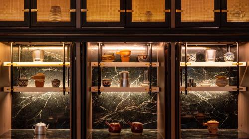 a display case with cups and shoes in it at Hotel Indigo Saigon the City by IHG in Ho Chi Minh City