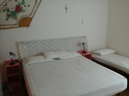 a bedroom with two beds and a cross on the wall at messina in Lido di Spina