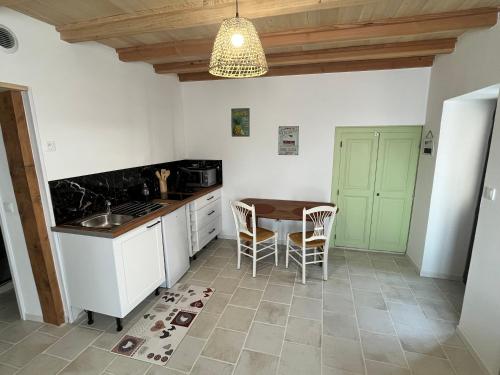 a kitchen with a table and chairs in a room at Maison du Bonheur in Cissé