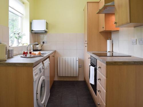 a small kitchen with a sink and a dishwasher at Cobb's Cottage in Grosmont