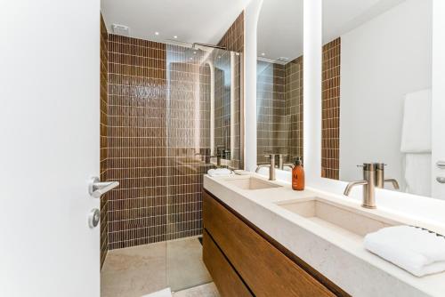 une salle de bain avec un lavabo et un grand miroir dans l'établissement Maisons Amore Saint Tropez, à Saint-Tropez