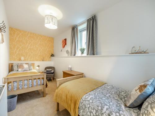 a bedroom with a bed and a desk and a window at South View in Haydon Bridge