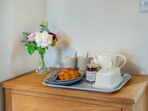 a tray with a plate of croissants and flowers on a table at South View in Haydon Bridge