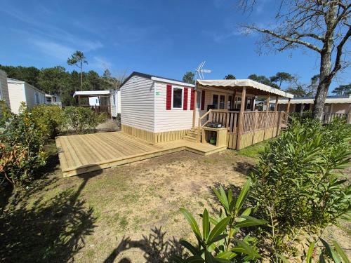 une petite maison avec un porche et une terrasse dans l'établissement La cabane oceane, à Lège-Cap-Ferret