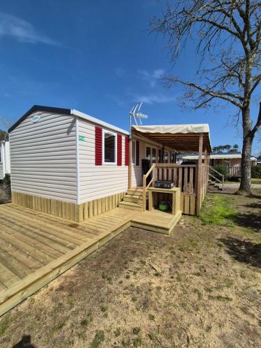 un mobil-home avec une terrasse et un gazebo dans l'établissement La cabane oceane, à Lège-Cap-Ferret