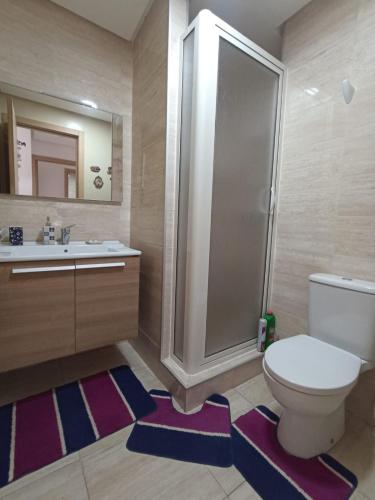 a bathroom with a toilet and a shower and a sink at Beralmar Asilah New in Asilah