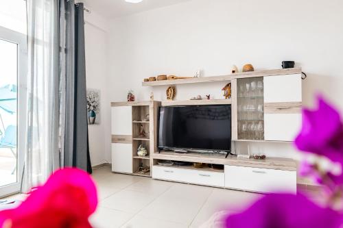 a living room with a television in a white entertainment center at The Bay Apartments in Sarandë