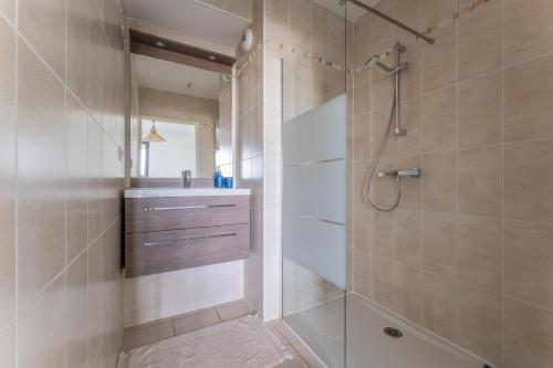 une salle de bain avec douche et lavabo dans l'établissement immeuble haut standing avec vue étang et parking, à Mauguio