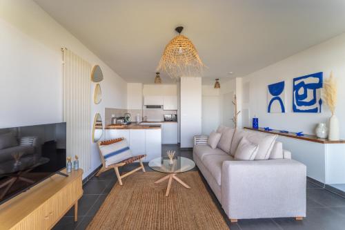 un salon avec un canapé et une table dans l'établissement immeuble haut standing avec vue étang et parking, à Mauguio