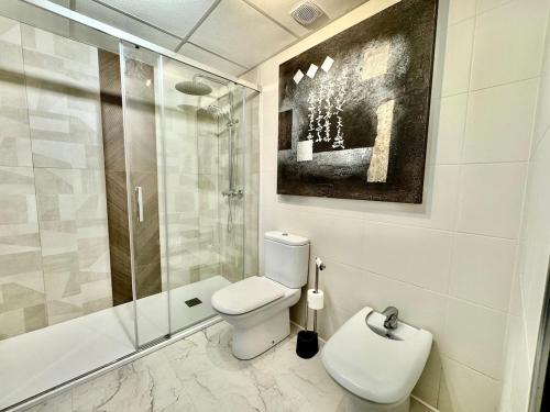 a bathroom with a toilet and a glass shower at Vacation Apartment in Els Poblets