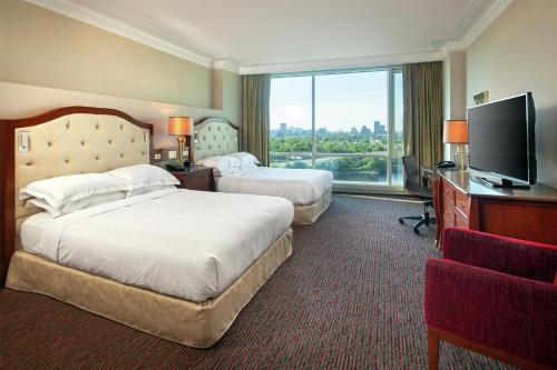 a hotel room with two beds and a flat screen tv at Hilton Lac-Leamy in Gatineau