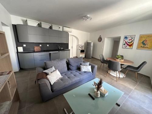 un salon avec un canapé bleu et une table dans l'établissement Nîmes Downtown Apartment, à Nîmes