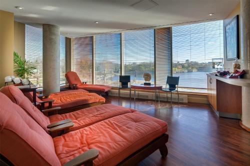 a living room with orange furniture and large windows at Hilton Lac-Leamy in Gatineau