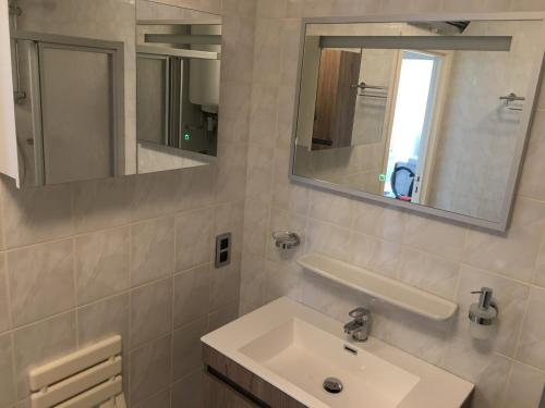 a bathroom with a sink and two mirrors at Aan zee in Nieuwpoort in Nieuwpoort