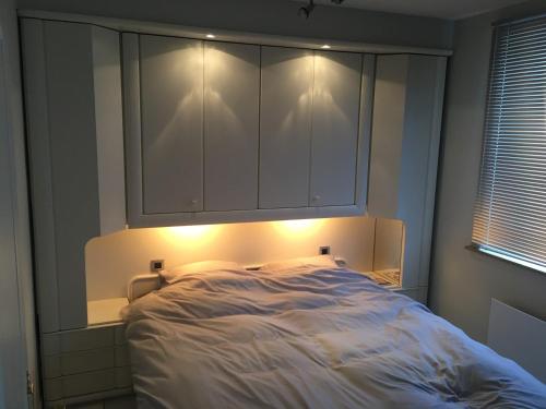 a bedroom with a bed with lights on it at Aan zee in Nieuwpoort in Nieuwpoort