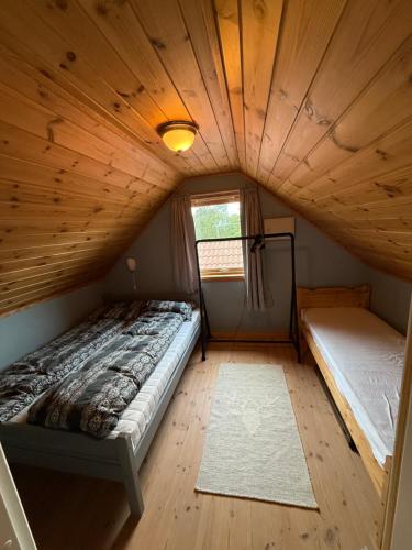 a small room with a bed and a window at Landlig hytte med jacuzzi in Lyngdal