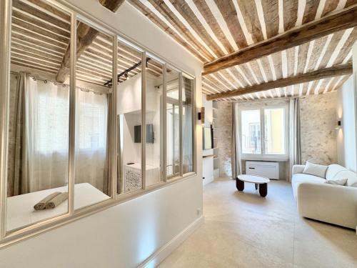 un salon avec un canapé et quelques fenêtres dans l'établissement Luxe et Charme sur les Remparts du Vieil Antibes, à Antibes