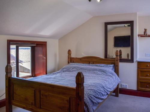 a bedroom with a wooden bed and a mirror at Seaside in Flamborough