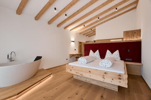 a bathroom with a tub and a bed and a sink at Lanzenschuster in San Genesio Atesino