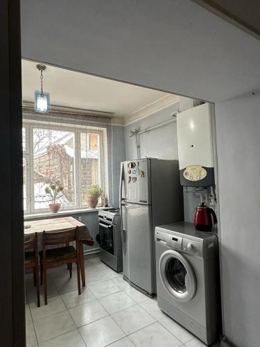 una cucina con lavatrice, tavolo e frigorifero di Aghayan Apartment a Gyumri
