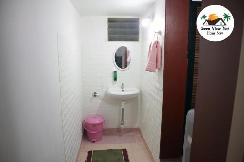 Un baño pequeño con lavabo e inodoro rosa. en Green View Nest Home Stay, en Shimoga