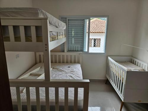 Ένα ή περισσότερα κρεβάτια σε δωμάτιο στο Casa em Boiçucanga com 2 suítes, piscina e sauna integrada