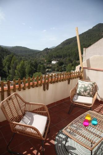 a patio with two chairs and a table on a balcony at La casita del tío tomas in Montanejos