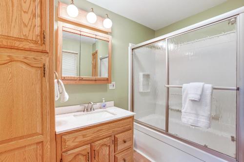 a bathroom with a shower and a sink and a glass shower door at Dock and Views Scenic Lakefront Escape in Harrison in Harrison