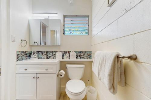 a bathroom with a toilet and a sink and a mirror at Puamana 30-2 in Lahaina