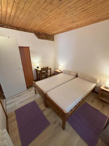 Cette chambre comprend un lit et deux tapis violets. dans l'établissement Le Villard appartement Adrech, à Abriès