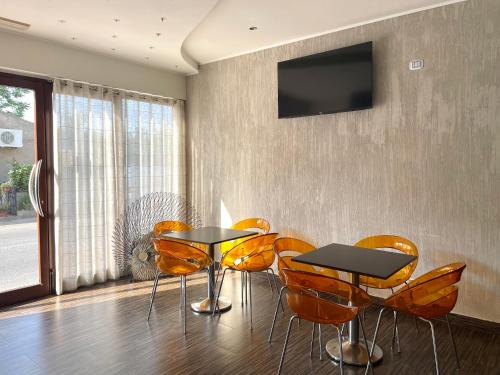 a dining room with two tables and orange chairs at Nacional B&B in Monforte San Giorgio Marina