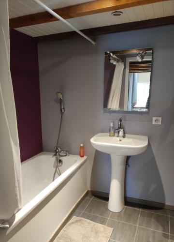 a bathroom with a sink and a bath tub at l'Echappée Crançotine in Crançot