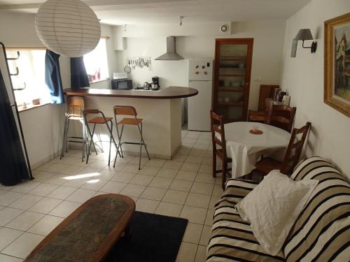 un salon et une cuisine avec un canapé et une table dans l'établissement Le Logis de Loulou, à Bayeux
