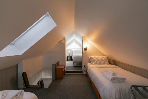 una camera mansardata con due letti e una finestra di Condo Resort - Gondola 4 min walk -Terrace a Mont-Tremblant