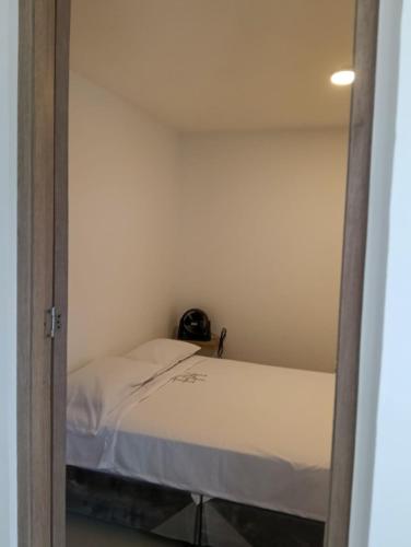a small bedroom with a bed and a mirror at Denier House II in Ibagué