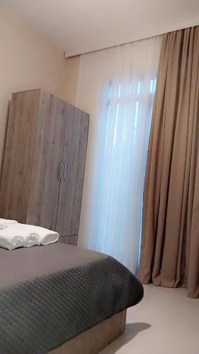 a bedroom with a bed and a wooden cabinet at Tsikhisdziri Panorama Cottage in K'obulet'i