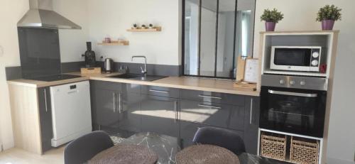 una cucina con lavello e microonde di Maison proche Clermont-Fd entre CHU et Cézeaux -Parking a Beaumont
