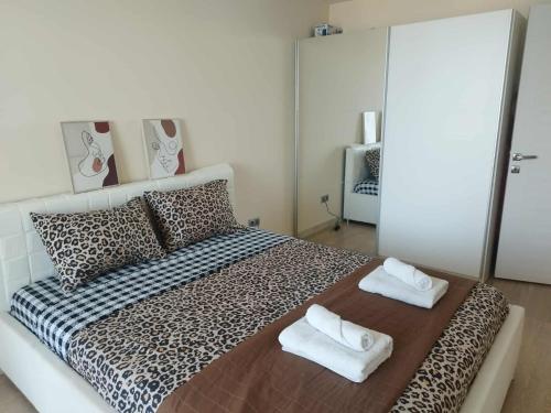 a bedroom with a leopard print bed with towels on it at Skopje Sky Apartments & Floor 33th 28th & 25th & 19th & 13th 12th With Pool & Spa & Fitness & Parking Included in Price in Skopje