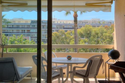 une table et des chaises dans une pièce avec une fenêtre dans l'établissement REF 1514 - Apartment with unobstructed view to rent, à Cannes