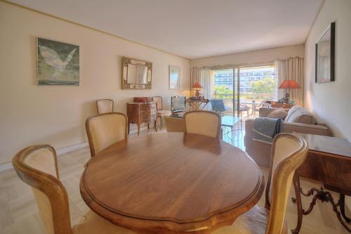 un salon avec une table et des chaises en bois dans l'établissement REF 1514 - Apartment with unobstructed view to rent, à Cannes