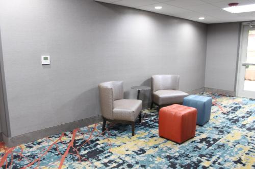 a waiting room with two chairs and luggage at Holiday Inn Express Shawnee by IHG in Shawnee